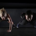 a man and woman doing push ups