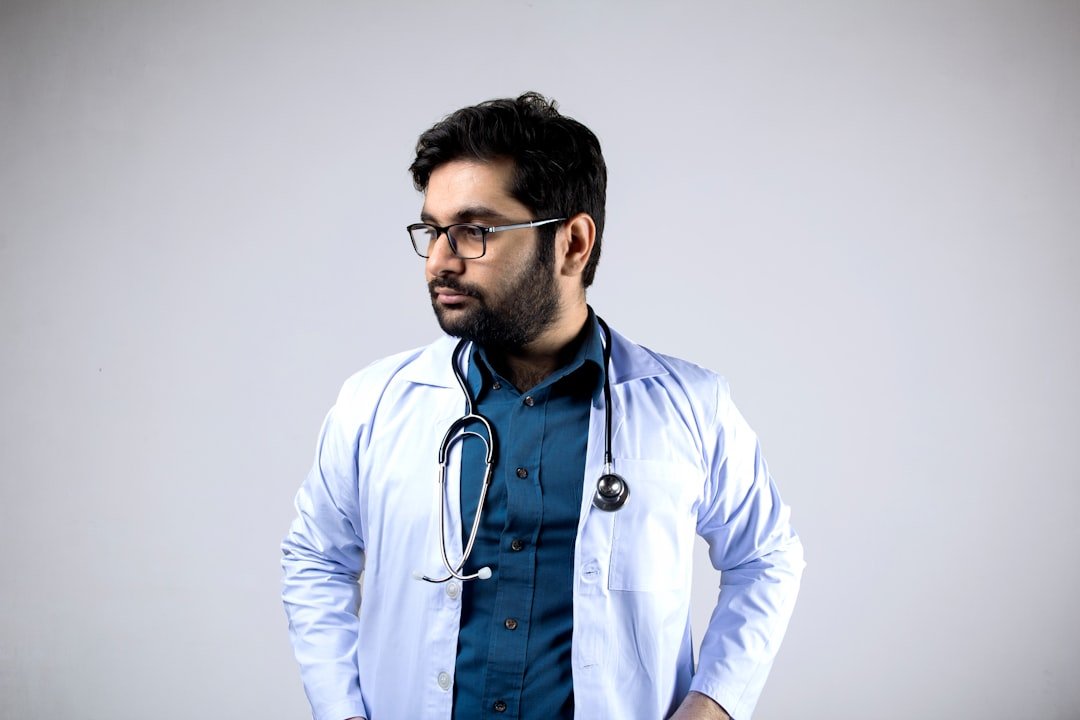 man in white and blue zip up jacket wearing black framed eyeglasses