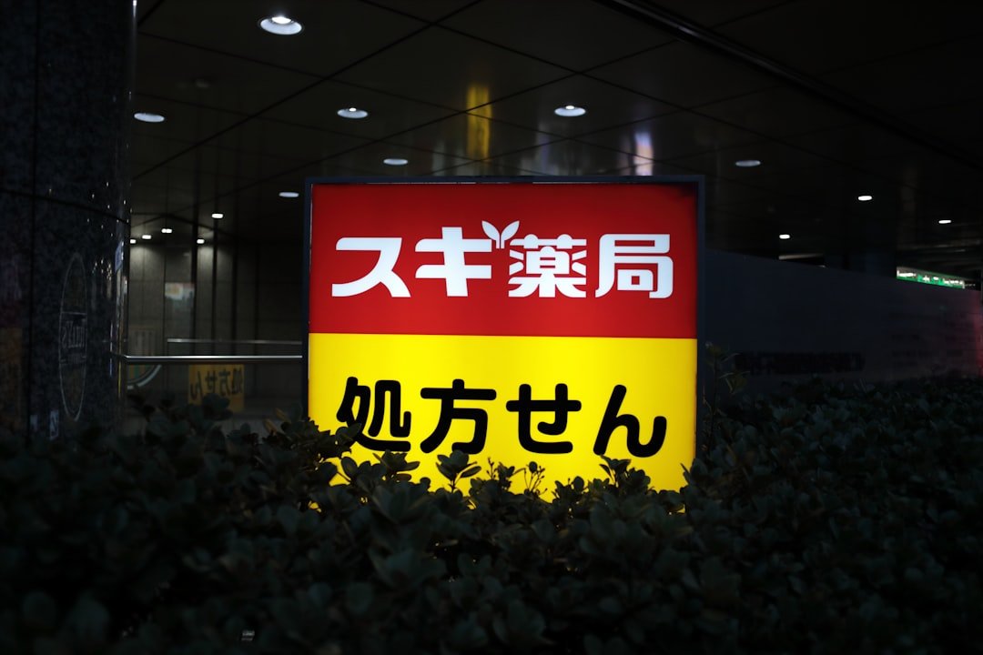 A red and yellow japanese sign illuminated at night.