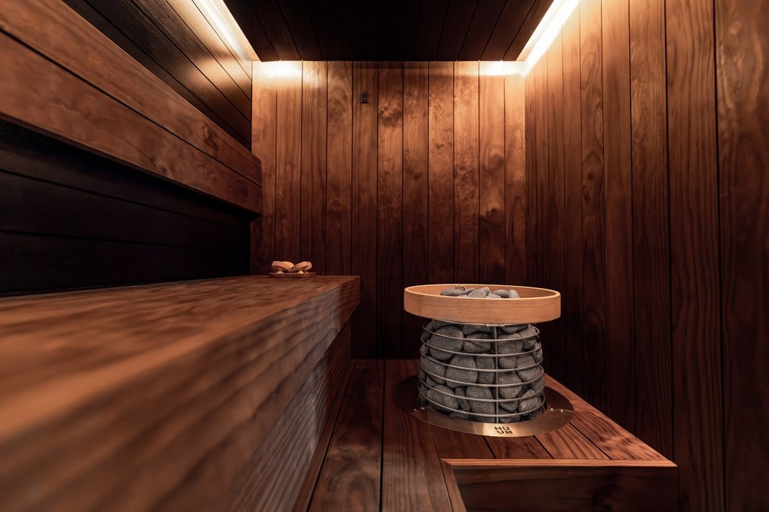 Modern wooden sauna interior with heater and warm lighting.
