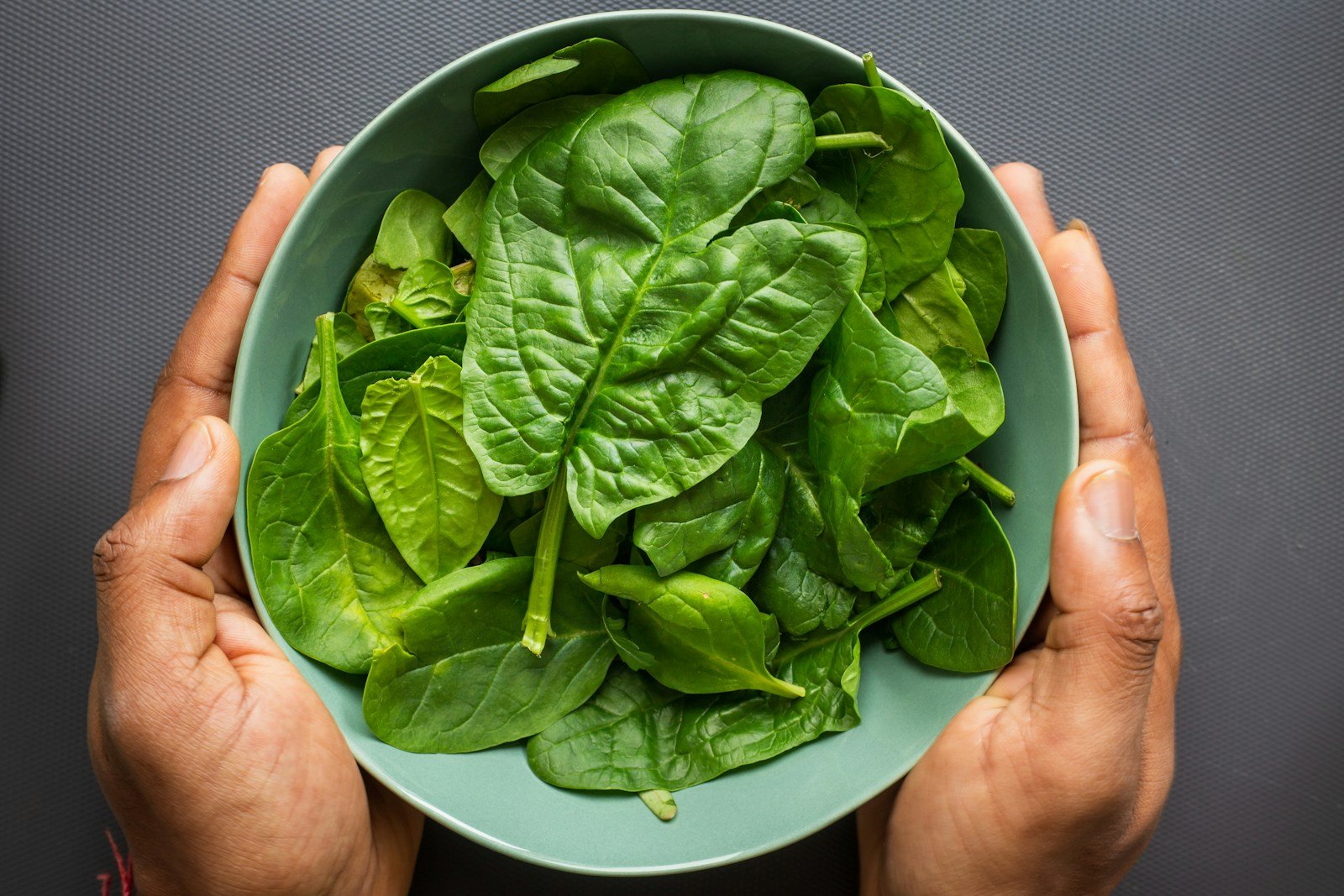 Fresh leafy green spinach in a bowl - a natural source of magnesium